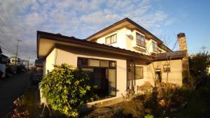 a small white house with a porch at AnBeeeNa in Akita