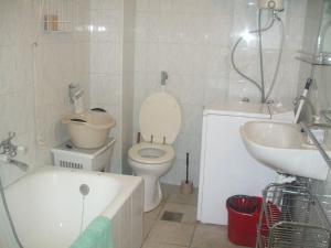 a bathroom with a toilet and a sink and a tub at Garabuczi Apartman in Keszthely