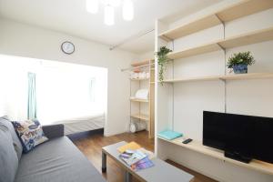 a living room with a couch and a tv at Roppongi Japan House602 in Tokyo