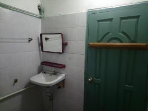 a bathroom with a green door and a sink at Diamond Star Guest House in Nyaungshwe Township