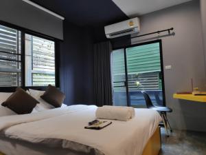 sypialnia z łóżkiem i 2 oknami w obiekcie Ratch66 Huai Khwang MRT w mieście Bangkok