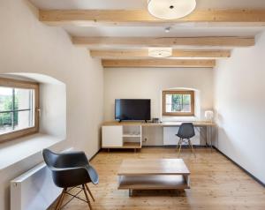 ein Wohnzimmer mit einem Schreibtisch und einem TV in der Unterkunft Hotel Kleis in Cvikov