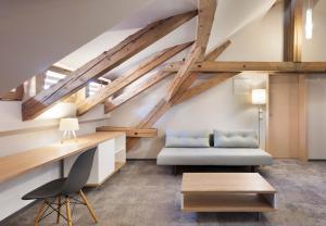 a living room with wooden ceilings and a couch and a table at Hotel Kleis in Cvikov