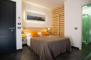 ein Schlafzimmer mit einem Bett mit orangefarbenen Kissen darauf in der Unterkunft InCentro B&B in Milazzo