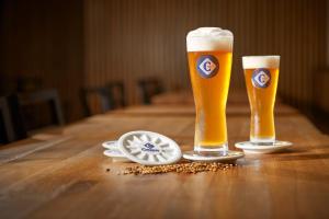 two glasses of beer sitting on a wooden table at Hotel Kleis in Cvikov