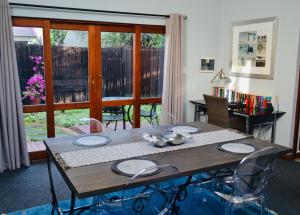 a dining room table with chairs and a wooden table at Serendipity Cottage in Johannesburg