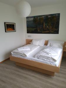 a large bed in a bedroom with a painting on the wall at Pension Residence Sonnenheim in Marlengo