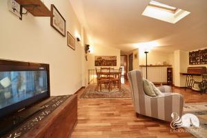 een woonkamer met een flatscreen-tv en een bank bij Country House in Desenzano del Garda