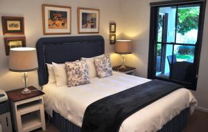 une chambre avec un lit avec deux lampes et une fenêtre dans l'établissement Blueberry Hill Cottages, à Franschhoek 39 autres photos