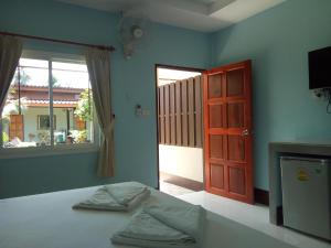 a bedroom with a bed and a red door and a window at Lanta Salamat House in Ko Lanta