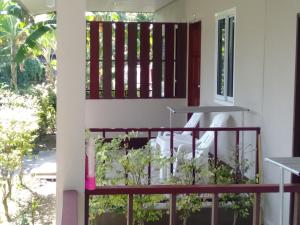 a balcony with a red railing and plants at Lanta Salamat House in Ko Lanta