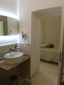 a bathroom with a sink and a bed at Stanze Orsini in Gravina in Puglia