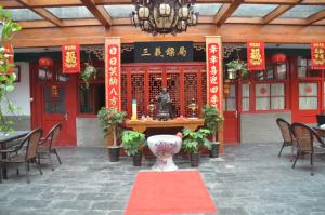 ein Restaurant mit einem Tisch mit einer Statue in der Mitte in der Unterkunft Qianmen Courtyard Hotel in Peking