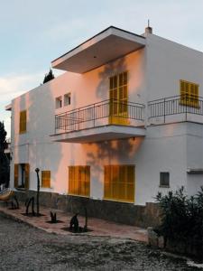 um grande edifício branco com muitas janelas em Hostal Catalina Vera em Port d’Andratx