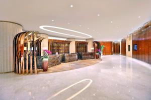 un pasillo de un edificio con bancos y mesas en Dongguan Kande International Hotel, en Dongguan