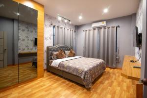 - une chambre avec un lit et une douche dans l'établissement GetZleep PoolVilla, à Sattahip