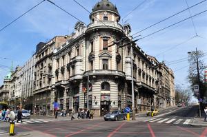 um edifício numa rua da cidade com um carro na frente em Habitat Hostel em Belgrado