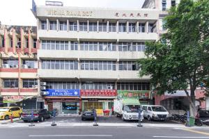 un grand bâtiment avec des voitures garées devant lui dans l'établissement Hotel Raja Bot, à Kuala Lumpur