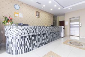 a lobby with a counter with a clock on the wall at Hotel Raja Bot in Kuala Lumpur