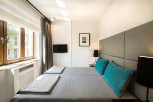 a bedroom with a large bed with blue pillows at Apartment with Terrace and Sauna by Grand Apartments in Sopot