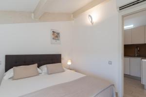 Un dormitorio con una cama blanca y una cocina. en Appartement DELICE A, en Saint-Tropez 5 fotos más
