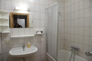 a white bathroom with a sink and a shower at Blaue Traube in Bad Aussee