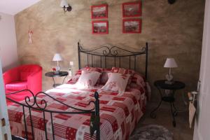 - une chambre avec un lit et une chaise rouge dans l'établissement Les gîtes du veau d'or, à Ozillac