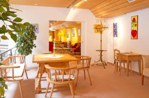 una sala da pranzo con tavolo e sedie in legno di Hotel Villa Post a Vulpera