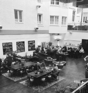 a group of people sitting at tables in a restaurant at Clarion Collection Hotel Plaza in Karlstad