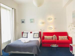 ein Schlafzimmer mit einem Bett und einem roten Sofa in der Unterkunft Nice Appart in Nizza