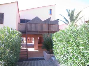 a building with a porch and bushes in front of it at MARE BELLU AGOSTA PLAGE in Albitreccia