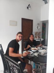 a man and woman sitting at a table eating food at Angelann Homestay in Cochin