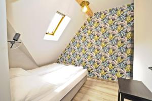 a room with a bed and a wall with a wallpaper at Grand Apartments - Superior Loft Apartment in Sopot