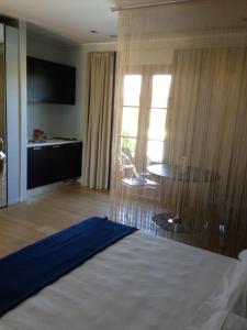 a hotel room with a bed and a table and window at Joia Hotel & Luxury Apartments in Brusaporto