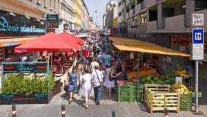 uma multidão de pessoas caminhando através de um mercado com produtos em Sweet Dreams em Viena