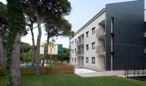 an apartment building with a fence next to a yard at SG Marina 54 Apartments in Castelldefels