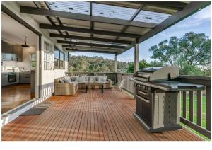 a screened in porch with a grill and a couch at Gracemont Boutique Accommodation in Healesville