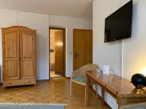 ein Wohnzimmer mit einem Tisch und einem TV an der Wand in der Unterkunft Hotel Bettelhaus in Bad Dürkheim
