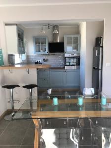 a kitchen with a glass table and some stools at 2BDR Reine Astrid in Cannes