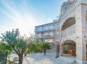 un edificio con un arco frente a un edificio en Pietra Mare Apartments, en Petrovac na Moru