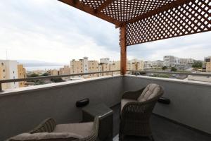 einen Balkon mit Stühlen und Stadtblick in der Unterkunft Suite dream in Eilat