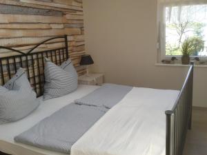 ein Bett mit weißer Bettwäsche und Kissen in einem Schlafzimmer in der Unterkunft Ferien am See in Schwerin