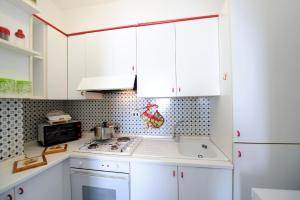 a kitchen with white cabinets and a stove top oven at LA TERRAZZA SUL MARE in Ravello
