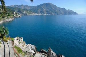 a view of a large body of water with mountains at LA TERRAZZA SUL MARE in Ravello +1 photo
