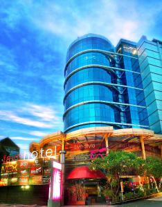 um edifício de vidro alto com uma placa em frente em favehotel MEX Tunjungan Surabaya em Surabaia