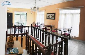 een eetkamer met tafels en stoelen en een kroonluchter bij Cloud Inn Kandy in Kandy