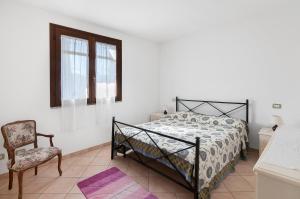 Primula 1 في مارينا دي كامبو: غرفة نوم بسرير وكرسي ونافذة
