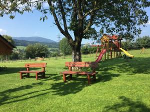 zwei Bänke in einem Park mit Spielplatz in der Unterkunft Penzion u Petra in Jeseník