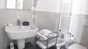 een witte badkamer met een wastafel en een spiegel bij Bonne Nuit Guest House in Azzano San Paolo +13 foto's