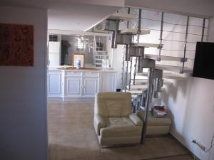 a living room with a chair and a spiral staircase at MARE BELLU AGOSTA PLAGE in Albitreccia
